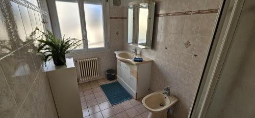 Un baño con lavabo, inodoro y ventana. en Maison agréable, quartier calme, en Lorient