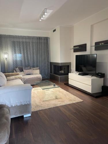 a living room with a couch and a flat screen tv at Sea view villa in Preveza