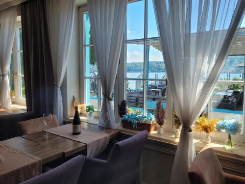 a restaurant with two tables and a large window at SEE-Hotel Seeschau - direkt am Bodenseeufer in Reichenau
