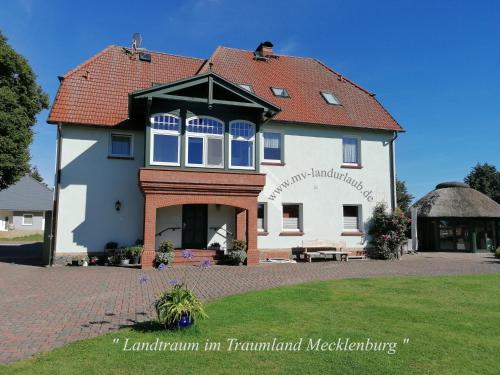 a large white building with a red roof at Landtraum im Traumland Mecklenburg in Warin