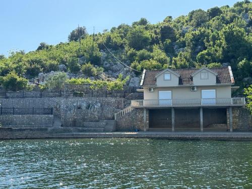 ポドゴリツァにあるLake Skadar Paradiseの水辺にある家
