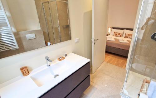 a bathroom with a sink and a mirror and a bed at HT - Basilica View Luxury Loft in Padova