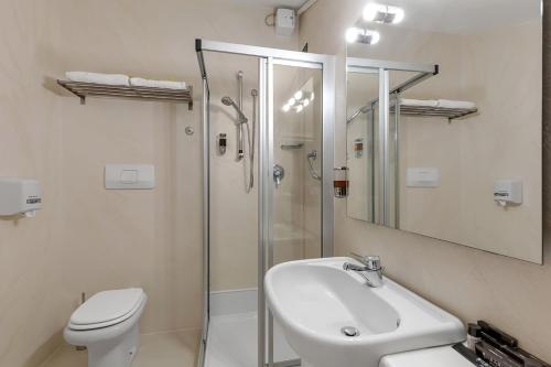 a bathroom with a toilet and a sink and a shower at Hotel Ancora in Verbania