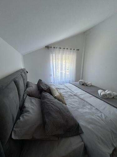 a large bed with pillows in a bedroom at Teodora Apartment in Kotor