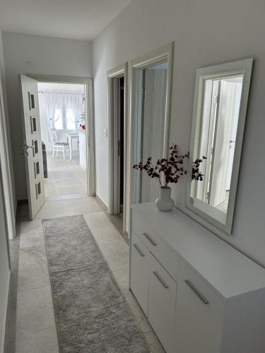 a white room with a dresser and a mirror at Teodora Apartment in Kotor