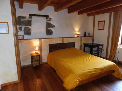 - une chambre avec un lit jaune et une cheminée dans l'établissement la ferme de theolier, à Pailharès