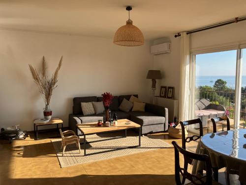 un salon avec un canapé et une table dans l'établissement Appartement T4 climatisé, lumineux et vue mer à Solenzara, à Sari-Solenzara