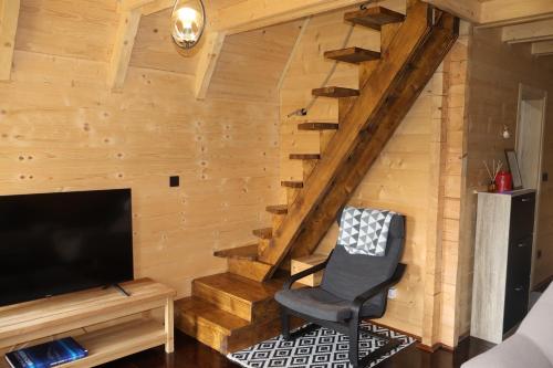 a room with a staircase and a chair and a television at Portes du Soleil - Zabljak in Žabljak