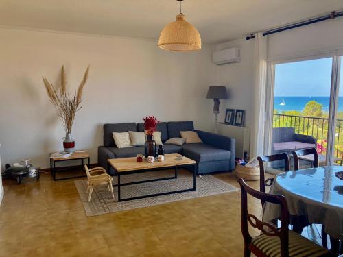 un salon avec un canapé bleu et une table dans l'établissement Appartement T4 climatisé, lumineux et vue mer à Solenzara, à Sari-Solenzara