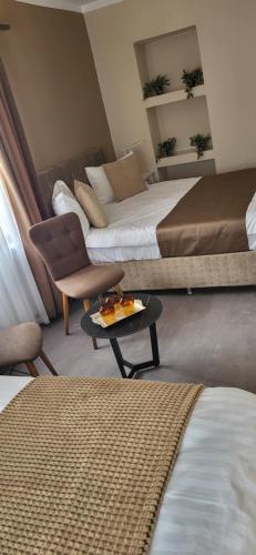 a hotel room with two beds and a table at Pensiunea Hanul Huniazilor HD in Hunedoara