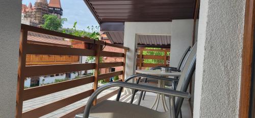 a balcony with chairs and a view of a building at Pensiunea Hanul Huniazilor HD in Hunedoara