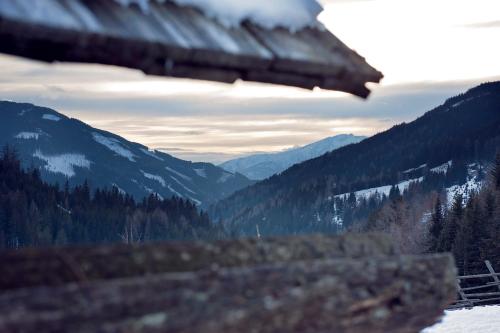 a view of a mountain valley with snow and trees at Sandrisser-Hütte in Innerkrems