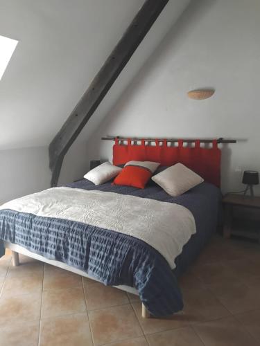 a bedroom with a bed with a red headboard at La longére du Lesty in Ambon