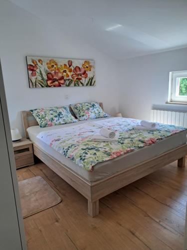 a bed in a bedroom with a painting on the wall at Apartment Oliva Volme in Banjole
