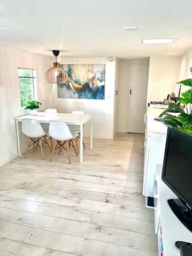 a kitchen and dining room with a white table and chairs at Huisje Eext - De Vos in Eext
