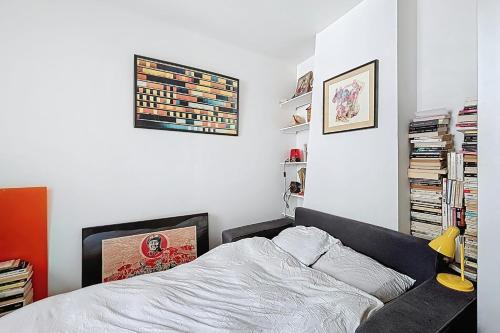 une chambre avec un lit et une étagère dans l'établissement Charming 2-room apartment near Montmartre, à Paris