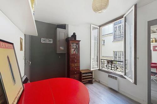 - une chambre avec un lit rouge et deux fenêtres dans l'établissement Charming 2-room apartment near Montmartre, à Paris