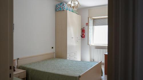 um pequeno quarto com uma cama e uma janela em Casa Cannulo em Otranto