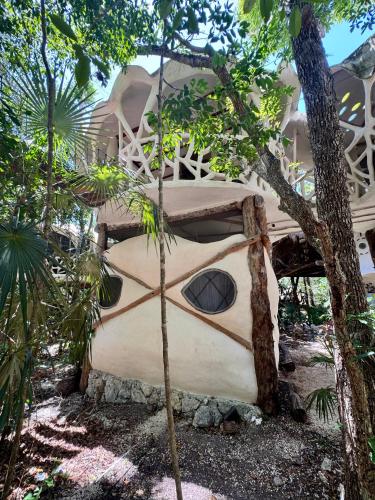 a tree house in the middle of a garden at Ikalar in Akumal