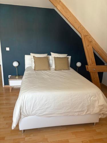 une chambre avec un lit blanc avec un mur bleu dans l'établissement Étage privatif dans grande maison, à Saint-Marceau