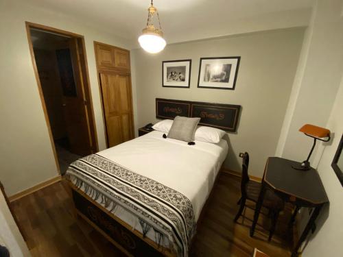 a bedroom with a bed and a lamp and a chair at Artinka Boutique Hotel in Cusco