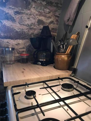 a stove top oven sitting next to a counter at Le gîte vouté confort et repos in Saint-Beauzély