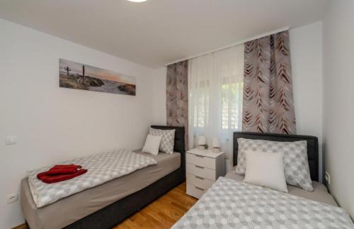 a bedroom with two beds and a dresser at Villa Oliva Petrcane in Petrcane