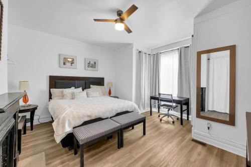 a white bedroom with a bed and a desk at Detroit 3BR in Mexicantown | Sleeps 7 + WiFi in Detroit