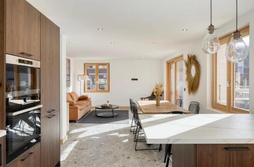 a kitchen and living room with a table and a dining room at Huxa Appt Megève Centre in Megève