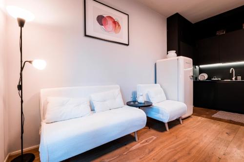 ベルガモにある2' Città Alta - Loft Moderno in Borgo Storicoのソファとテーブルと冷蔵庫のあるリビングルーム