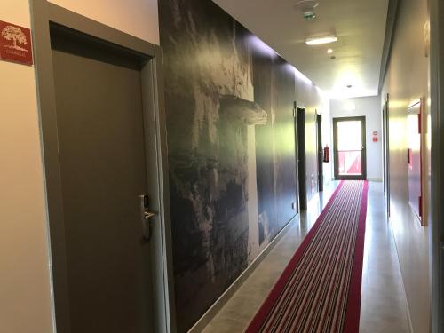 a hallway with a door and a red carpet at Hotel Rural da Catraia in Chão Redondo
