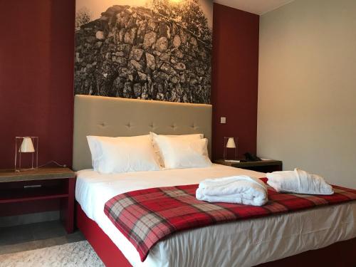 a bedroom with a bed with two towels on it at Hotel Rural da Catraia in Chão Redondo