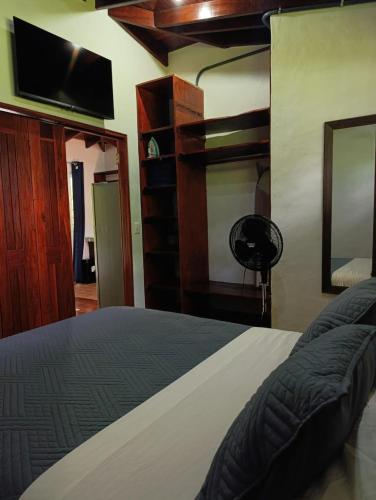 a bedroom with a bed and a flat screen tv at Villas Kiki in Puerto Viejo