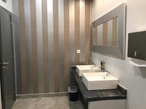 a bathroom with two sinks and a mirror at Hotel Rural da Catraia in Chão Redondo