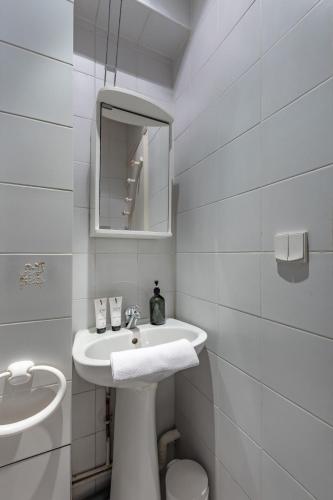 une salle de bain blanche avec un lavabo et un miroir dans l'établissement Cosy apartment well located in Paris center, à Paris