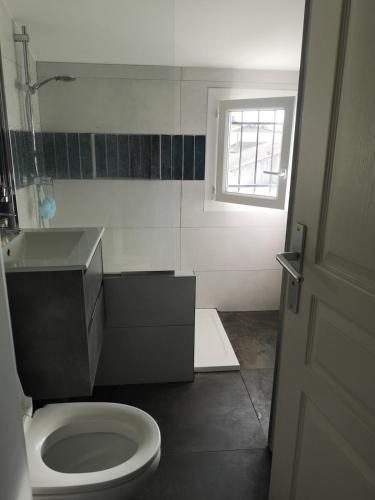une salle de bain avec toilettes, lavabo et fenêtre dans l'établissement Belle maison familiale avec piscine, city stade, et nombreuses activités, à Cournonterral