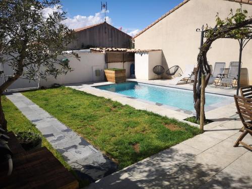 une cour arrière avec une piscine et une cour avec une pelouse sidx sidx dans l'établissement Belle maison familiale avec piscine, city stade, et nombreuses activités, à Cournonterral
