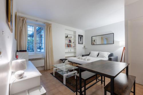 un salon avec une table et un canapé dans l'établissement Cosy apartment well located in Paris center, à Paris