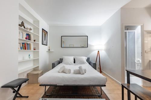 une chambre blanche avec un lit et une table dans l'établissement Cosy apartment well located in Paris center, à Paris