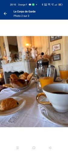 un tavolo con un piatto di pane e una ciotola di succo d'arancia di Le Corps de Garde a Saint-Martin-de-Ré
