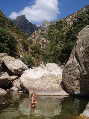 une femme debout dans l'eau d'une rivière dans l'établissement Simons Vacances, à Hérépian