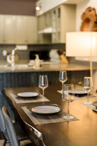 a wooden table with plates and wine glasses on it at Island Vista - Waterfront Condo in Tofino