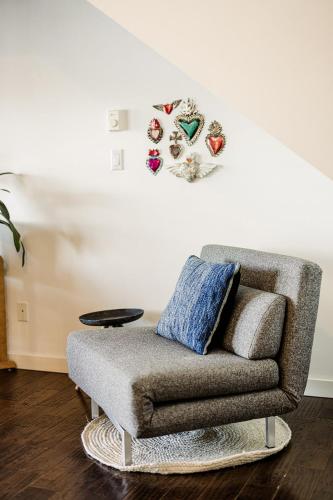 a chair in a living room with a clock on the wall at Island Vista - Waterfront Condo in Tofino