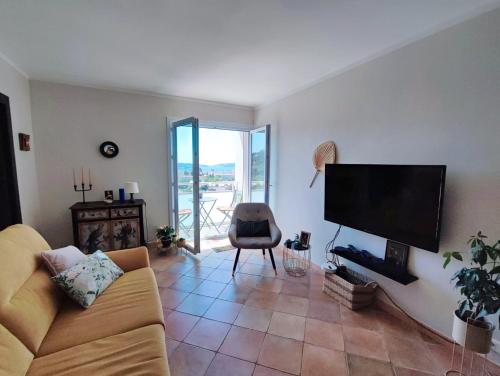 un salon avec un canapé et une télévision à écran plat dans l'établissement Charmant appartement T3 avec Vue dominante, à Toulon