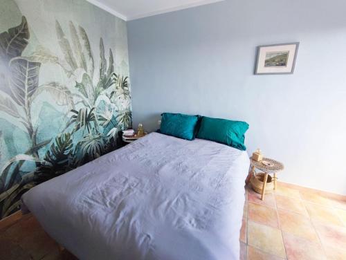 une chambre avec un grand lit avec des oreillers bleus dans l'établissement Charmant appartement T3 avec Vue dominante, à Toulon