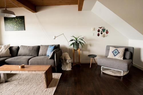 a living room with a couch and a table at Island Vista - Waterfront Condo in Tofino