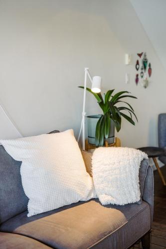 a couch with a pillow on it in a living room at Island Vista - Waterfront Condo in Tofino