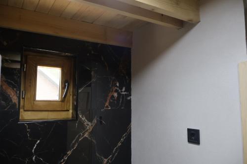 a window in a room with a black wall at Portes du Soleil - Zabljak in Žabljak