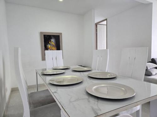 a table with four white plates on top of it at Top18 in Ibagué
