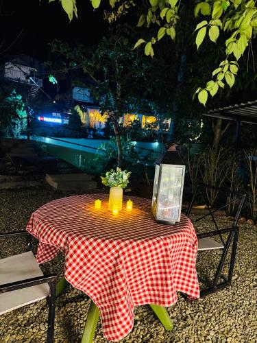 a table with candles and a vase of flowers on it at Paradise Pool Resort in Nainital